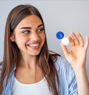 Smiling lady with a contact lens case in hand