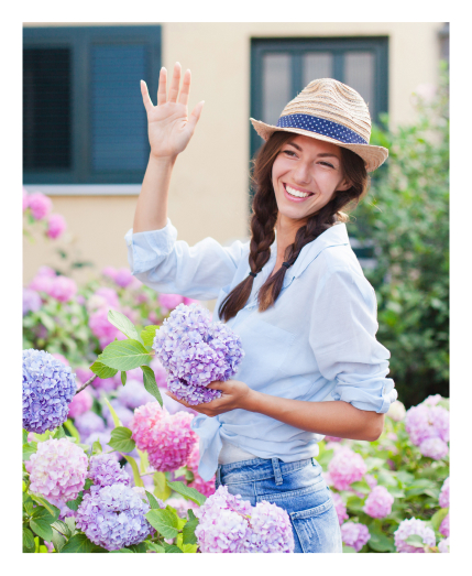 Woman waving hello while holding a flower