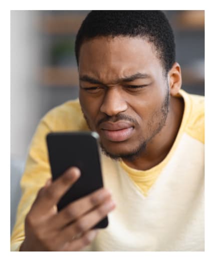 Man squinting and struggling to look at his phone.