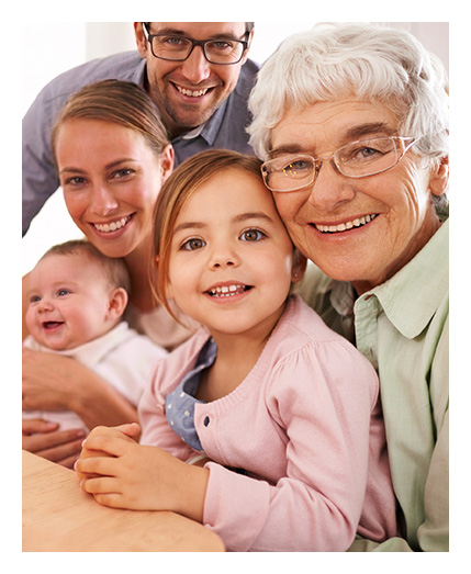 A multi-generational family, including an elderly woman wearing eyeglasses, a young girl, a woman, a baby, and a man wearing glasses.