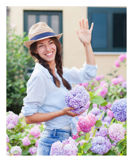 Woman waving hello while holding a flower